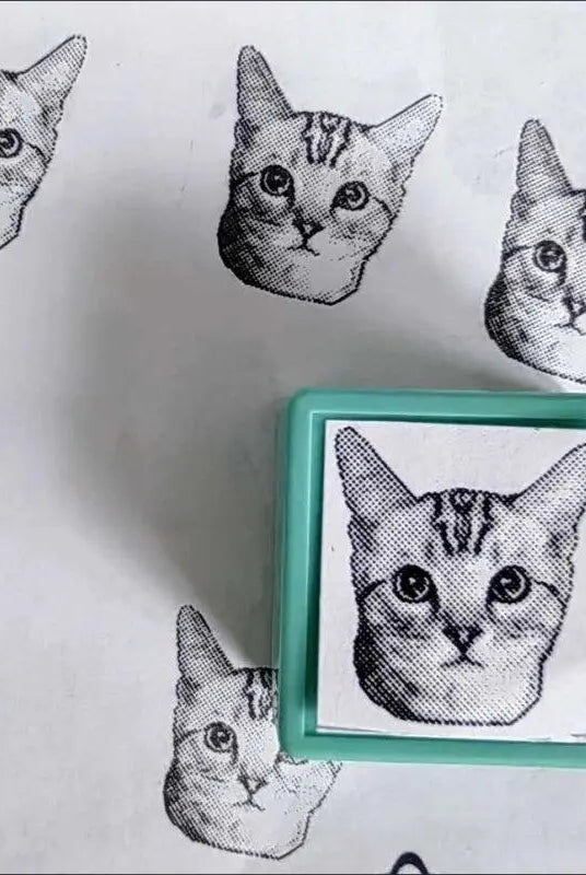 A green custom stamp with Sphnx portrait and beside the stamp displaying prints of the Sphnx cat stamp prints