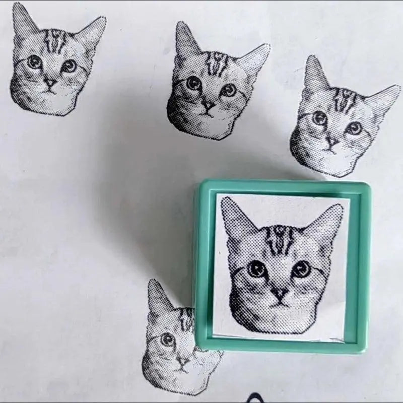 A green custom stamp with Sphnx portrait and beside the stamp displaying prints of the Sphnx cat stamp prints