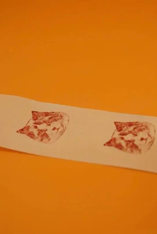 two head prints of a rag doll cat on a piece of paper left by the personalized stamp