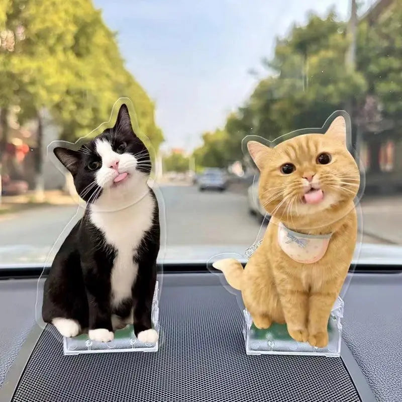two customized cat bobbleheads standing toghether in the car